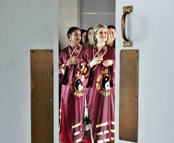 People in ceremonial robes smiling together in a doorway